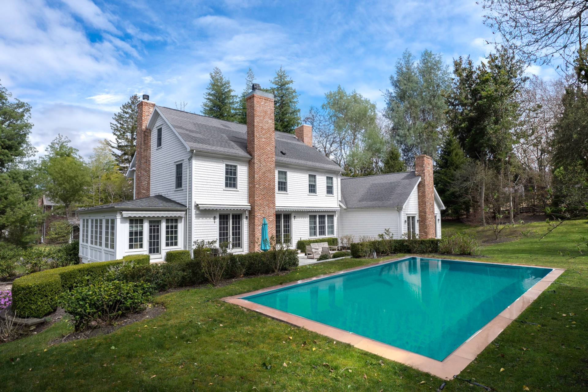 a view of a house with pool yard and trees