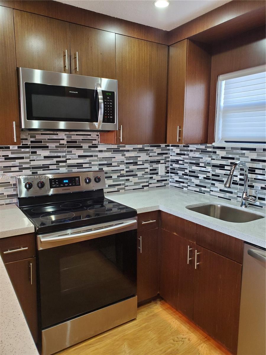 a kitchen with granite countertop a stove and a sink