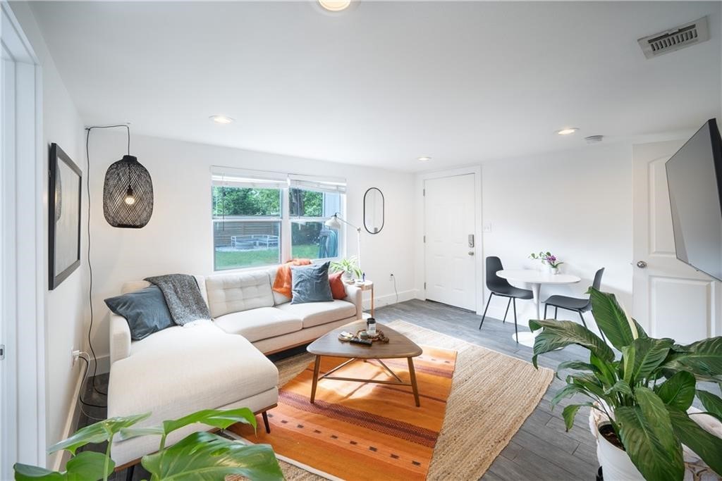 a living room with furniture a clock and a large window