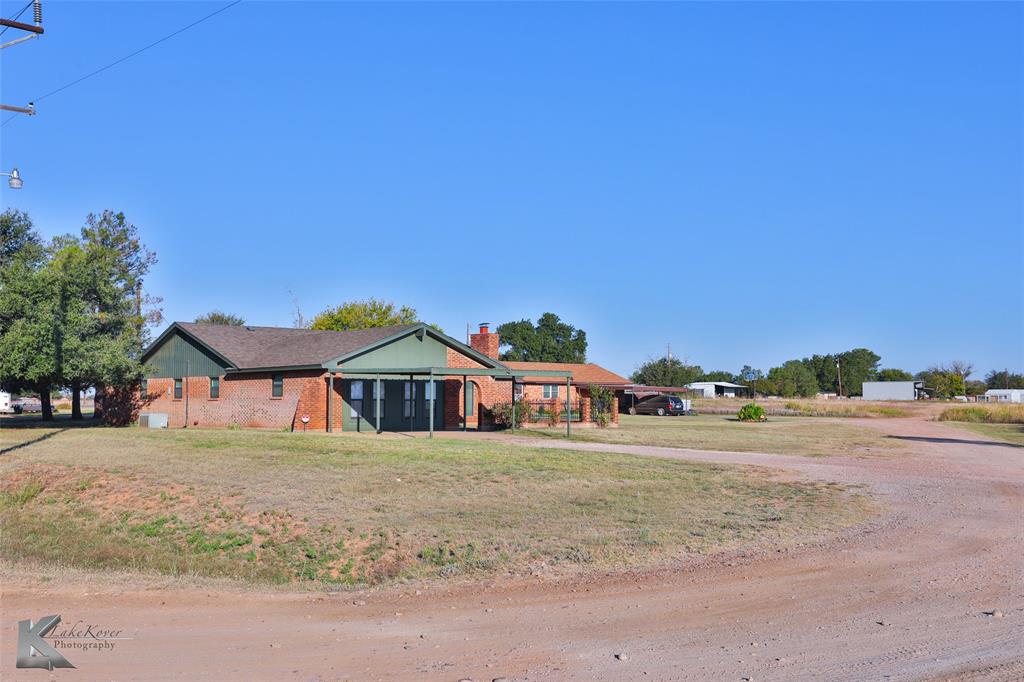 a front view of a house with a yard and road