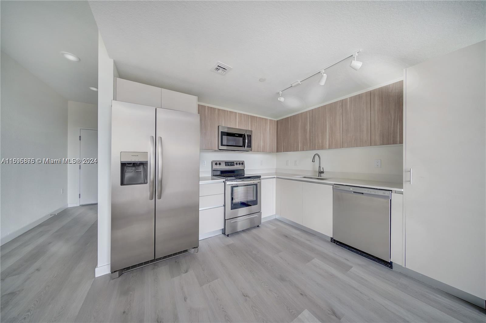 a kitchen with white cabinets and stainless steel appliances