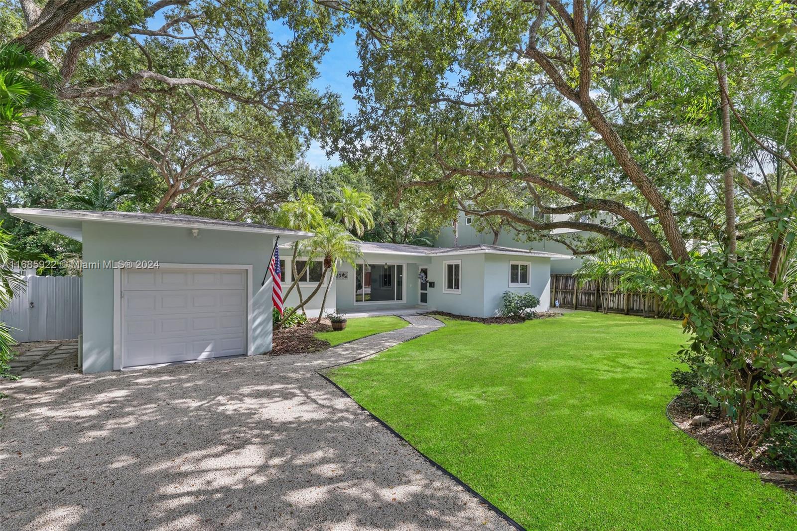 a front view of a house with a yard and trees