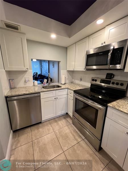 a kitchen with a sink a stove and cabinets