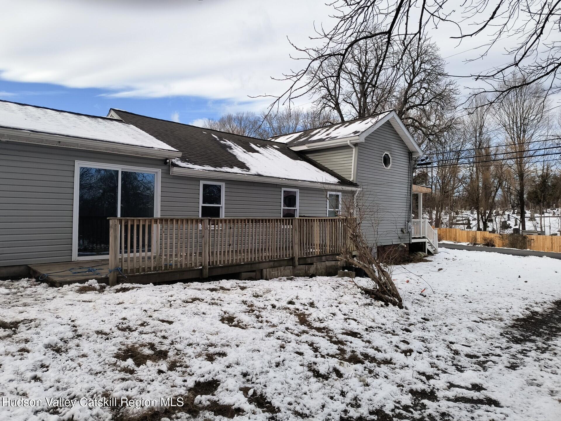 a front view of a house with a yard covered in snow