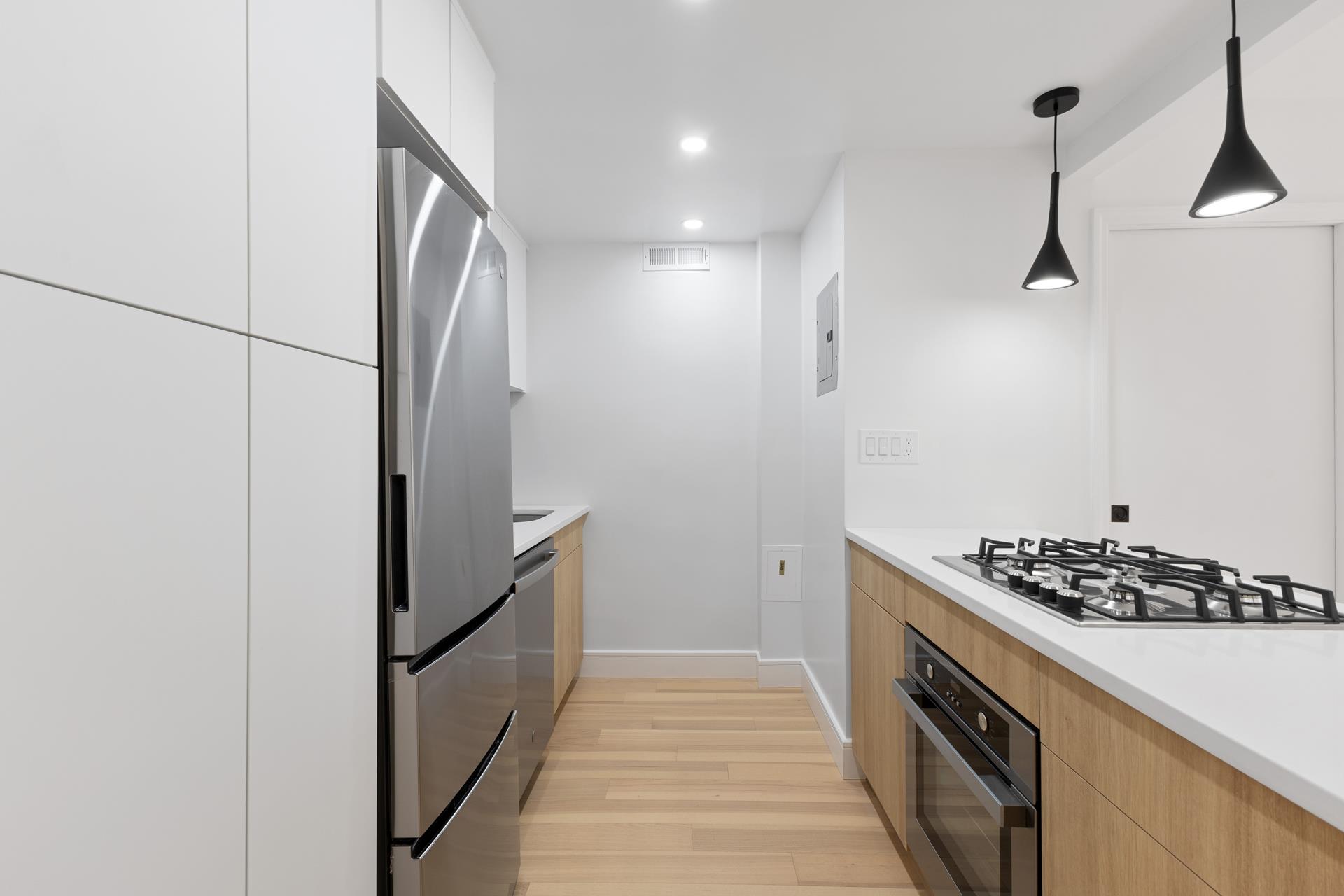 a kitchen with stainless steel appliances granite countertop a refrigerator and a stove top oven