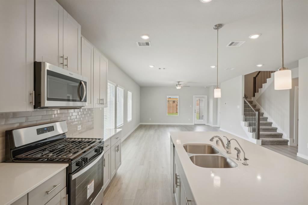 a kitchen with a sink and a stove top oven