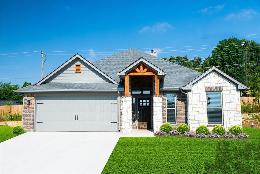 a front view of a house with a garden and plants