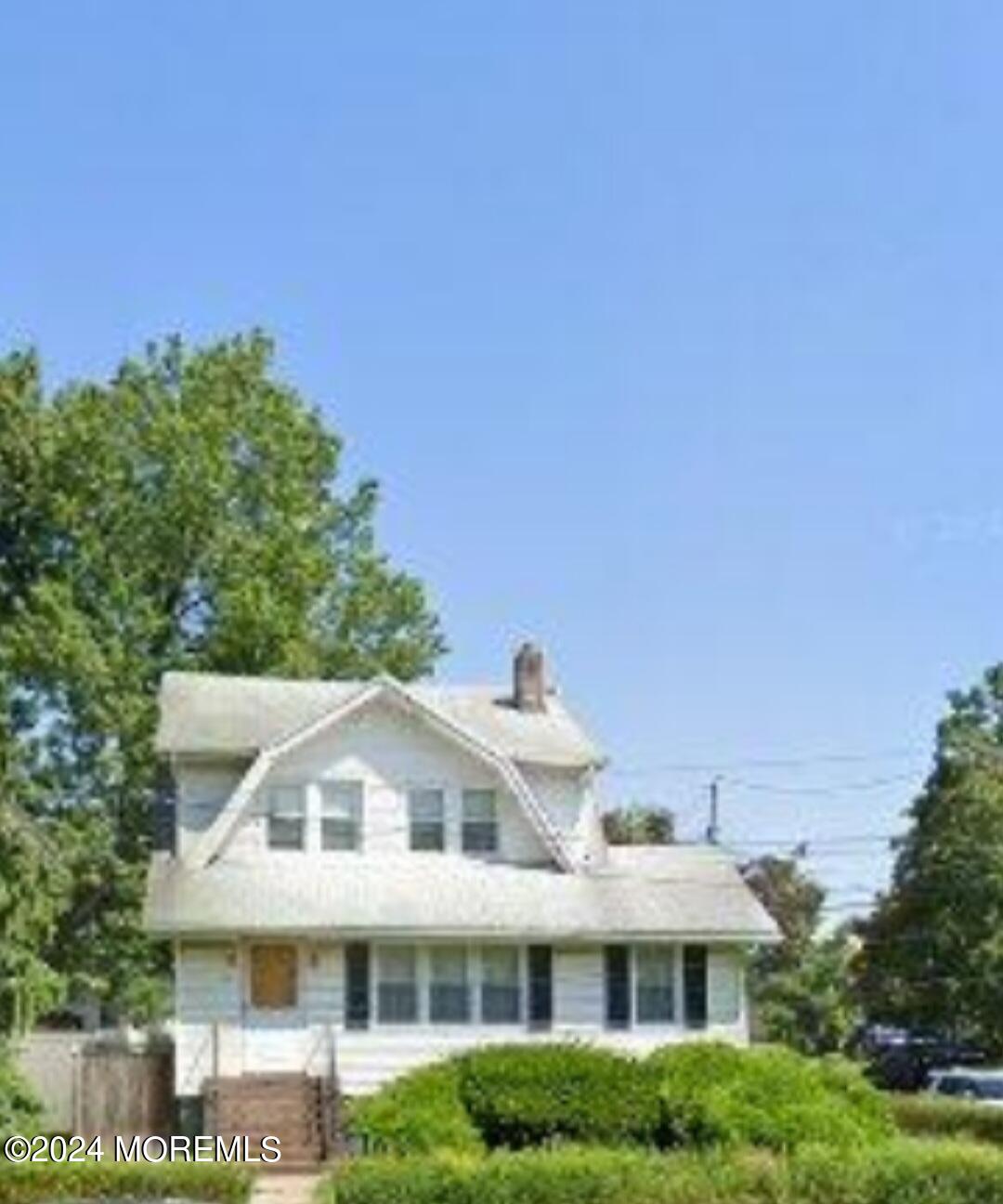 a front view of a house with a yard and trees