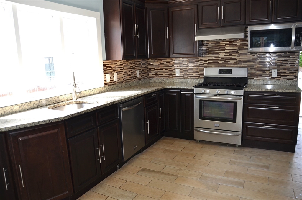 a kitchen with stainless steel appliances granite countertop a stove and a microwave