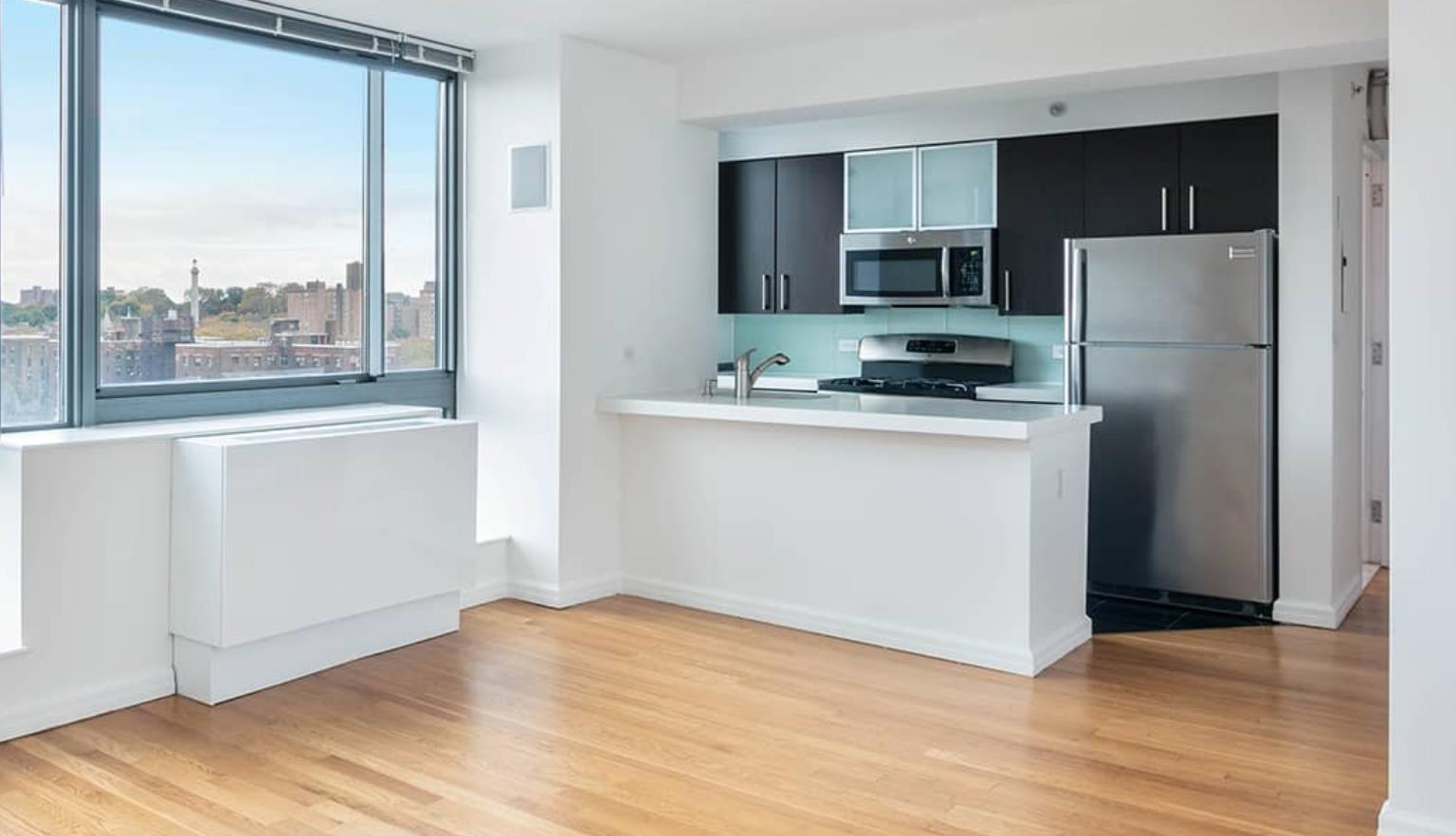 a kitchen with a refrigerator a stove top oven and wooden floor