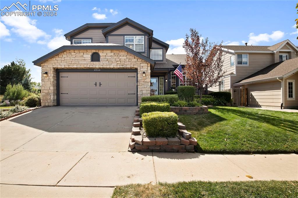 a front view of a house with a yard and garage