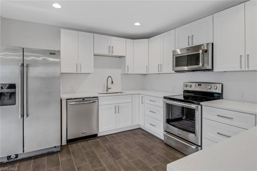 a kitchen with cabinets stainless steel appliances and a counter space