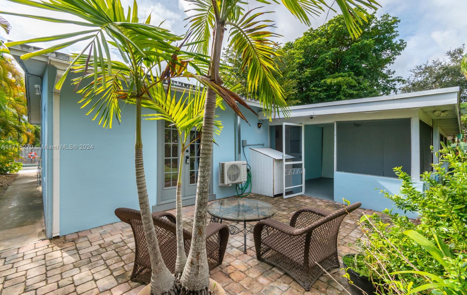 a view of a chair and table in backyard of the house