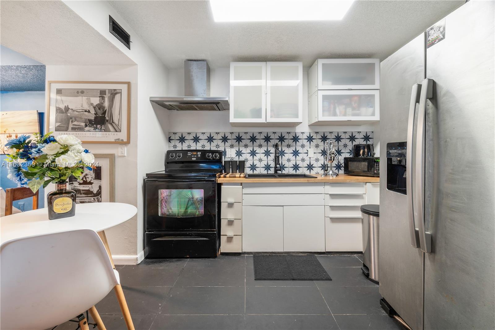 a kitchen with a refrigerator and a stove top oven