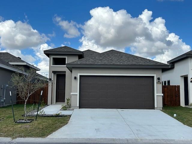 View of front of home with a front lawn and a garage