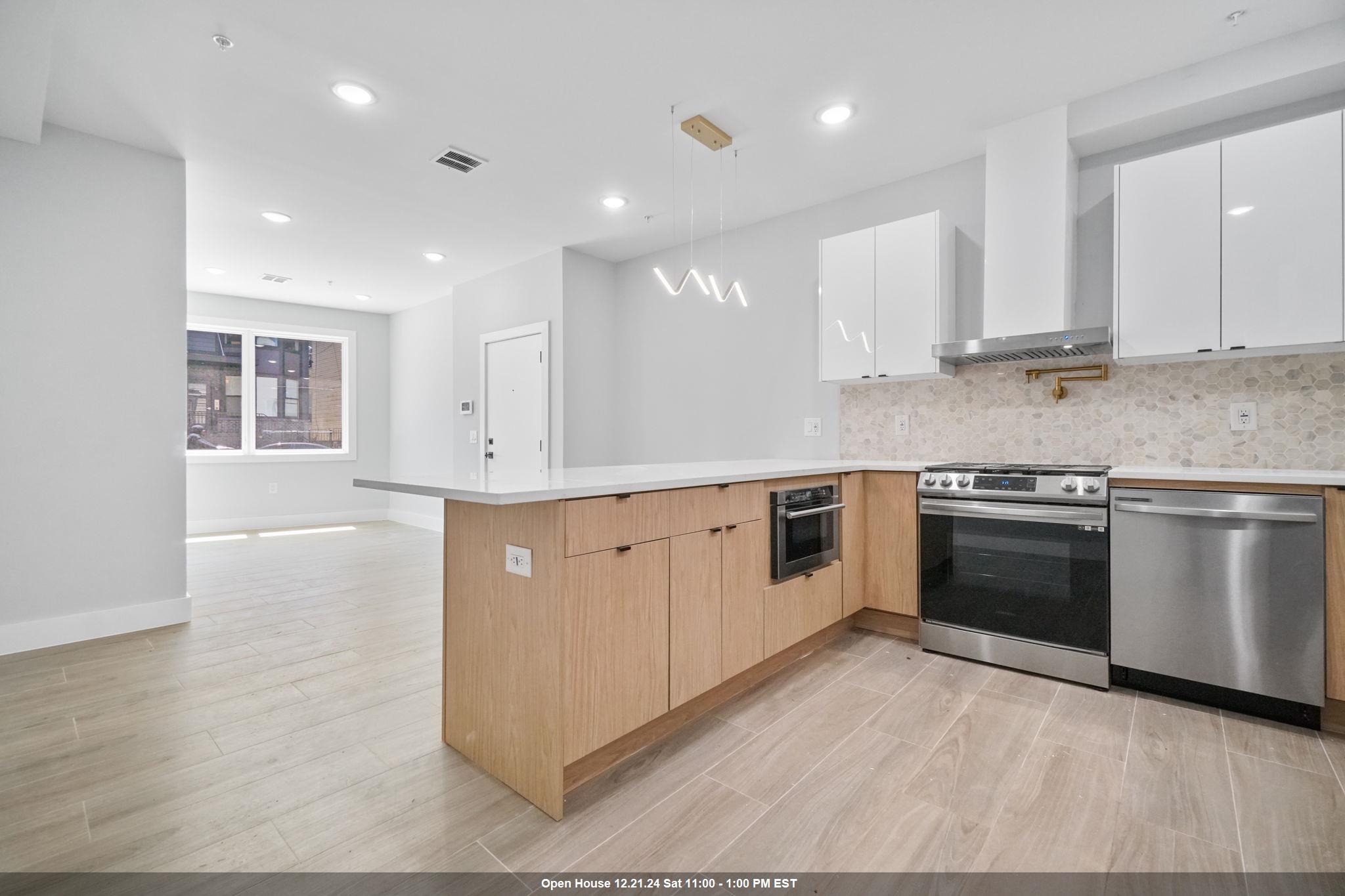 a kitchen with granite countertop a stove top oven sink and cabinets