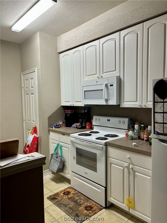 a kitchen with white cabinets and white appliances