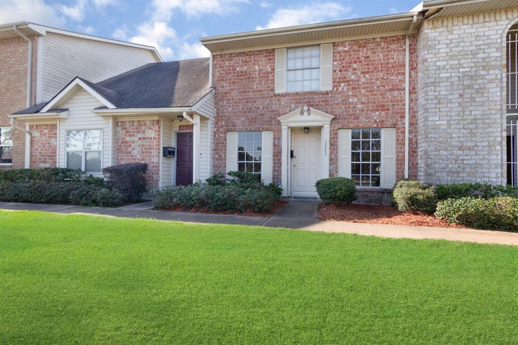 a front view of a house with a yard and potted plants