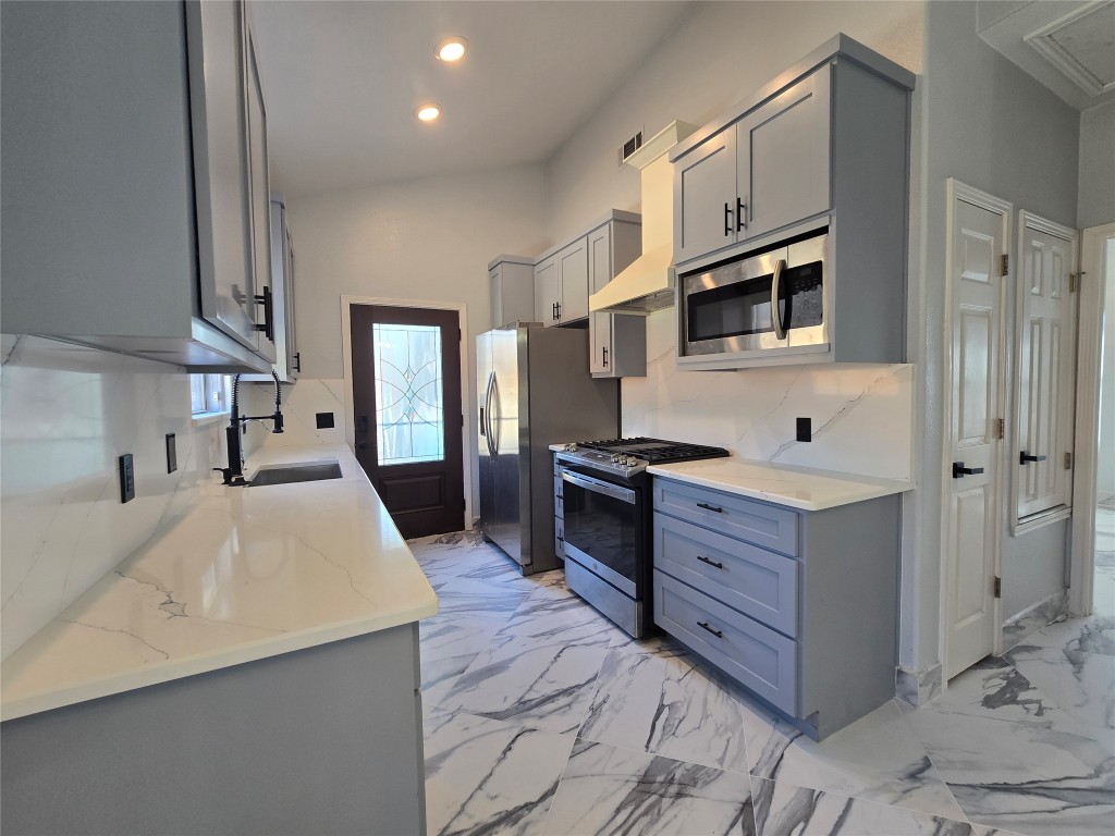 a large white kitchen with stainless steel appliances