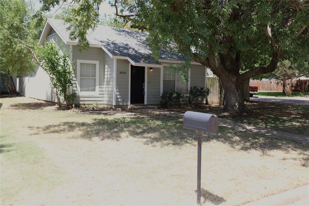 a front view of a house with yard and trees