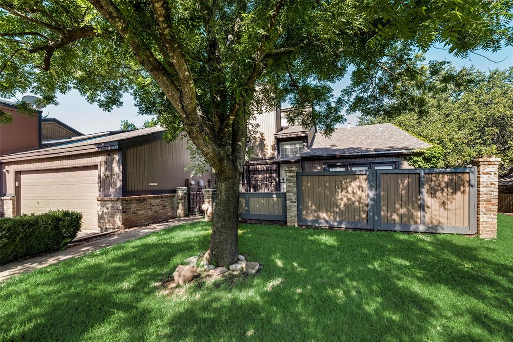 a view of a house with backyard and a tree