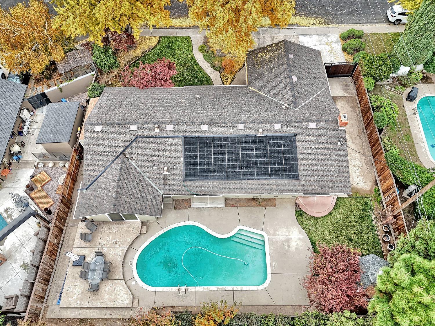 an aerial view of a house with a yard and a large tree