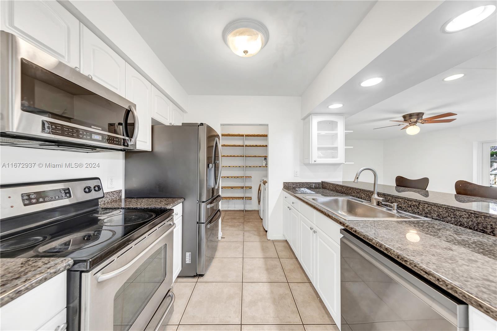 a kitchen with stainless steel appliances granite countertop a sink and a stove