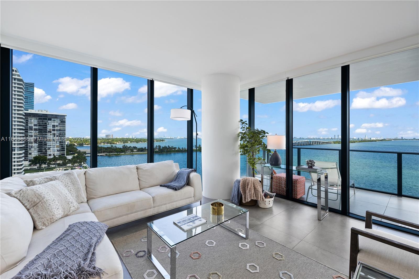 a living room with furniture and floor to ceiling windows