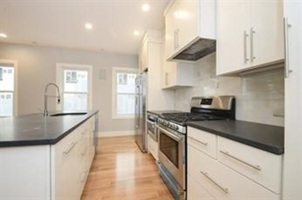 a kitchen with granite countertop a sink a stove and cabinets