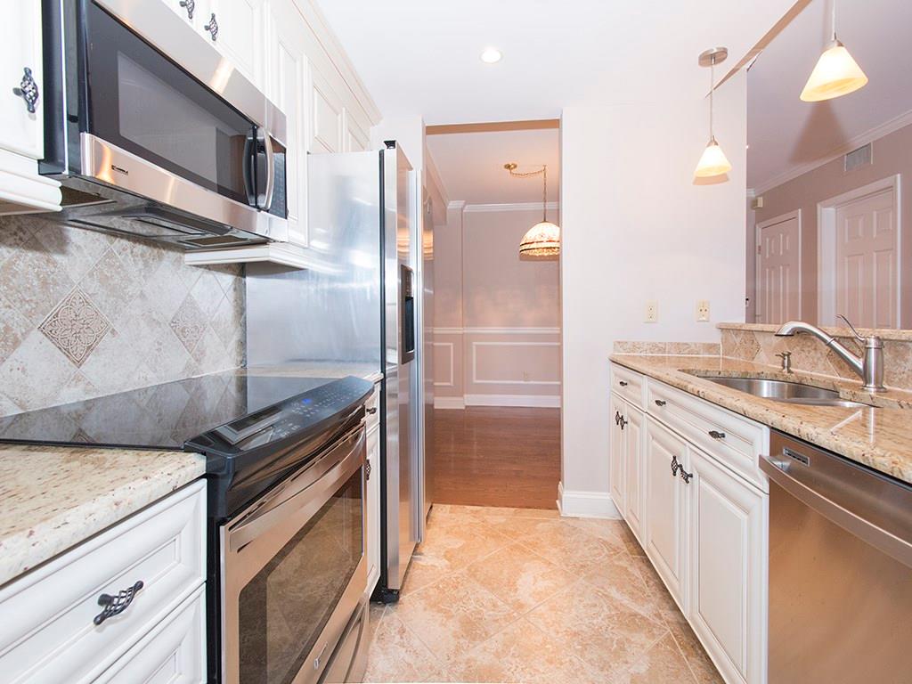 a kitchen with stainless steel appliances granite countertop a sink and a stove