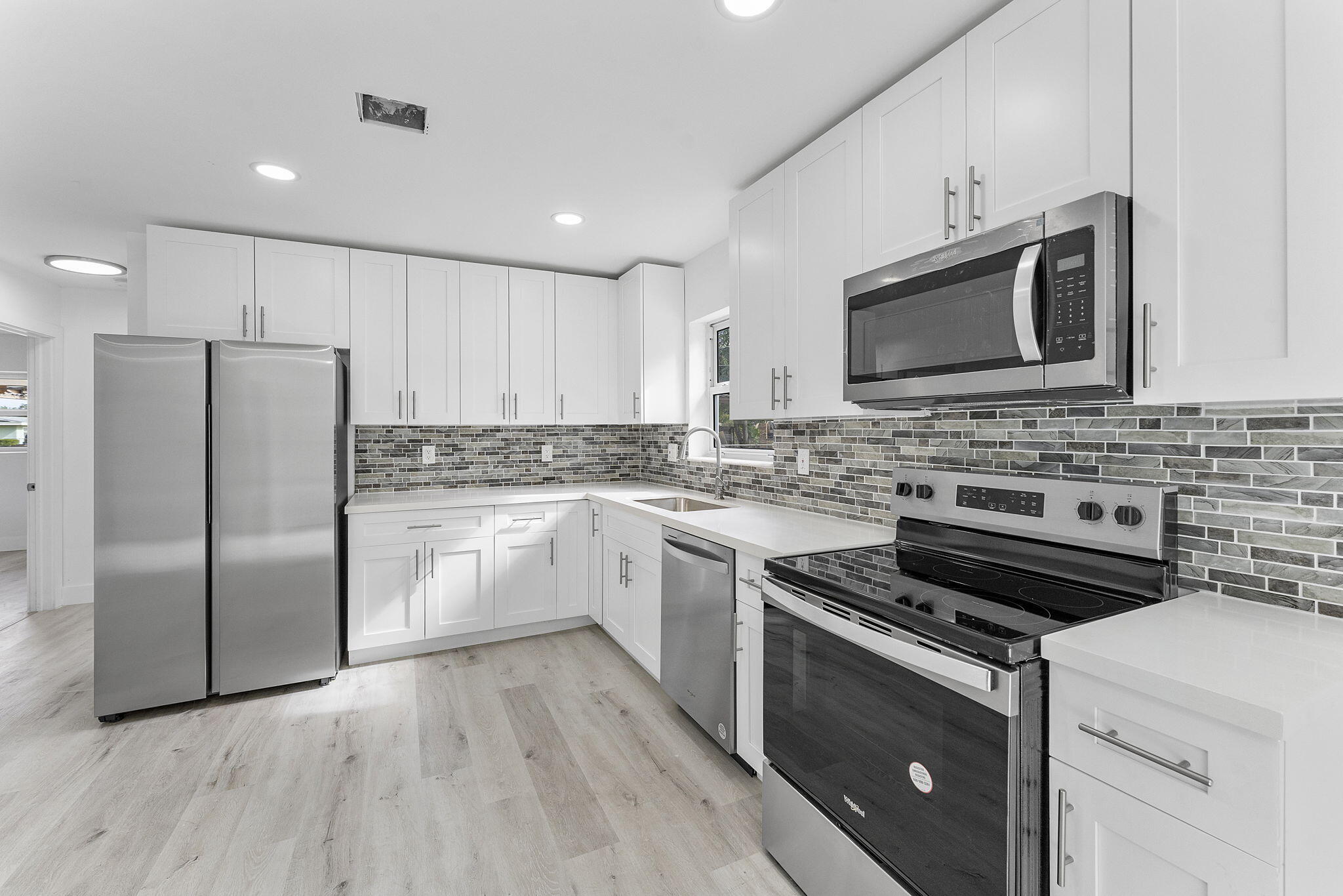 a kitchen with cabinets stainless steel appliances and a counter space