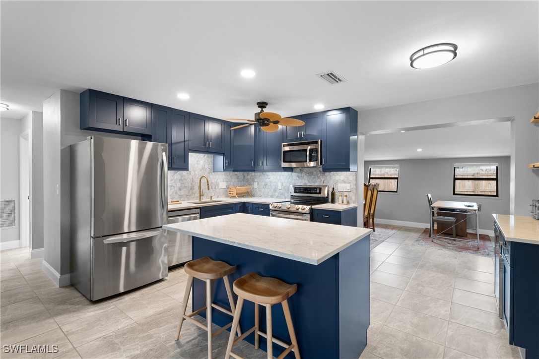 a kitchen with a table chairs refrigerator and microwave