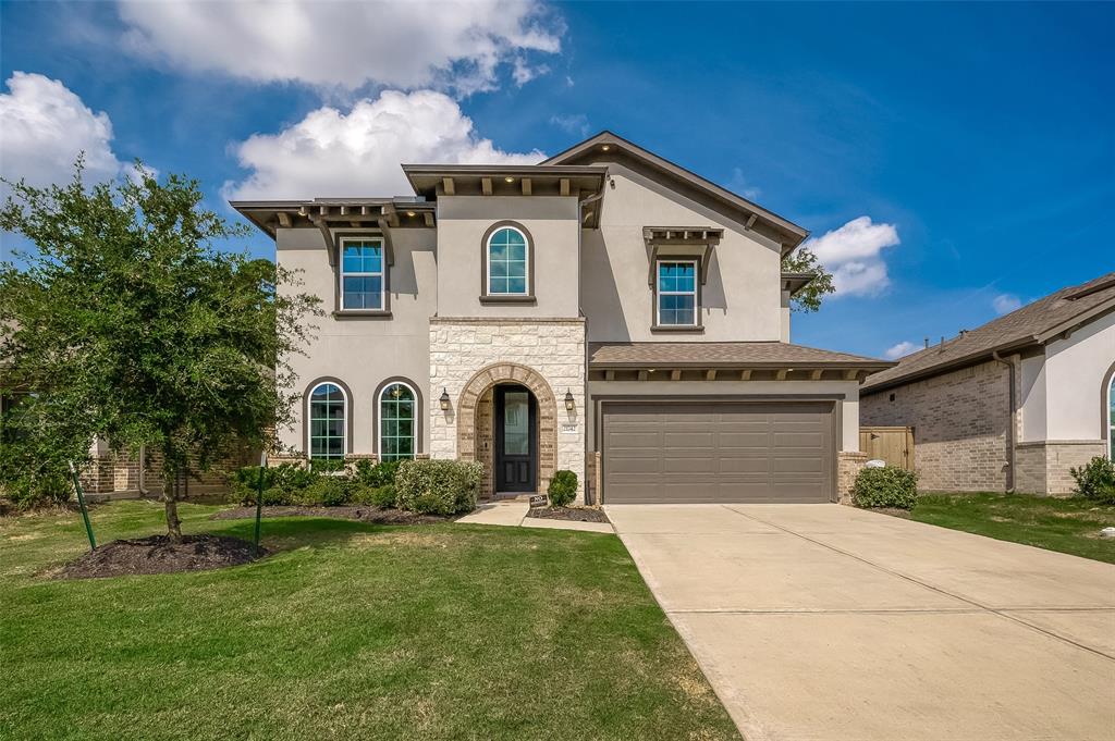 Welcome to 21742 N. Enchanted Rock Dr in Porter, Texas - a modern two-story home featuring a stone and stucco facade, a neatly landscaped front yard, and two-car garage boast major curb appeal