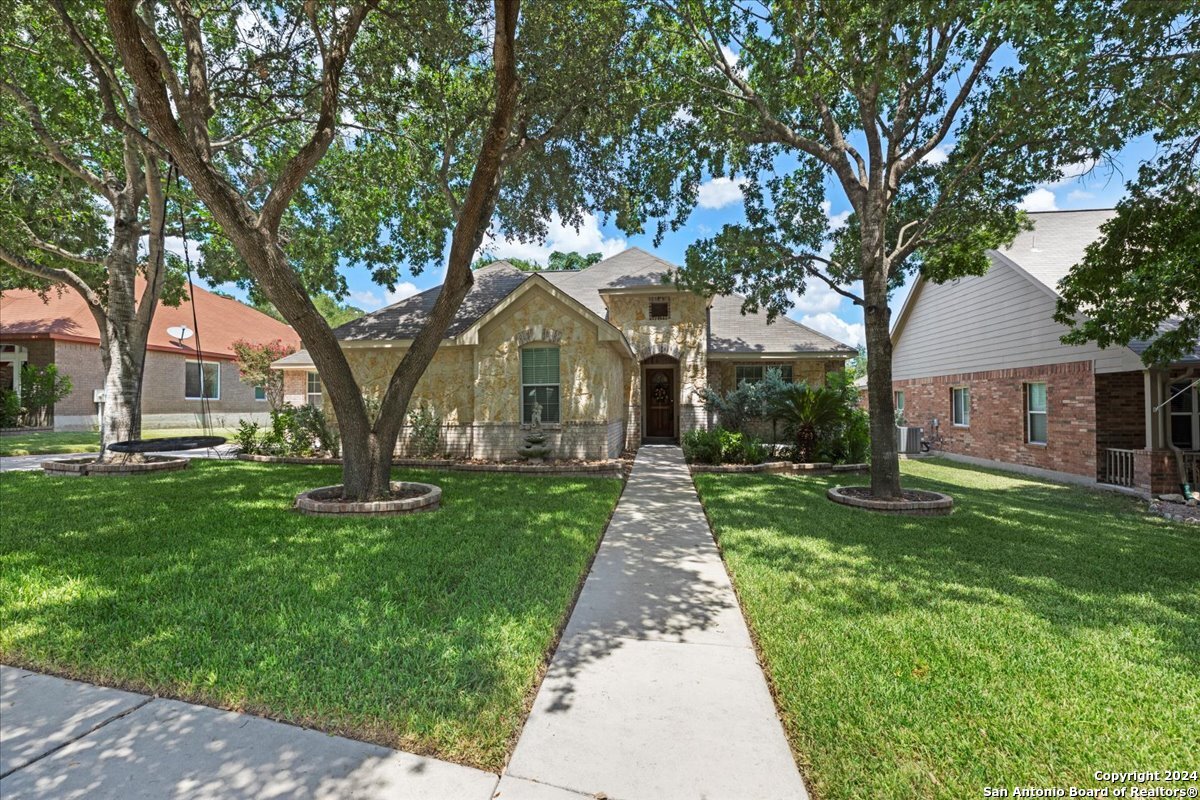 a front view of a house with a yard and trees