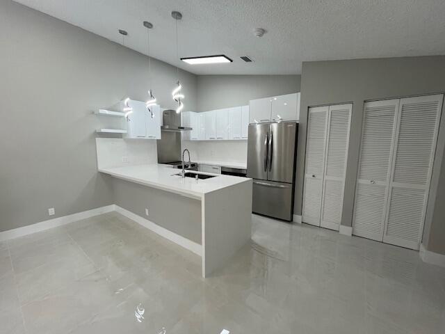 a kitchen with stainless steel appliances a refrigerator and a stove top oven