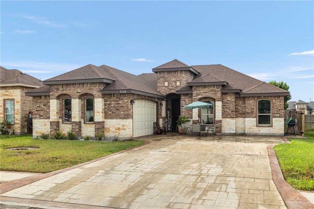 a front view of a house with a garden and yard