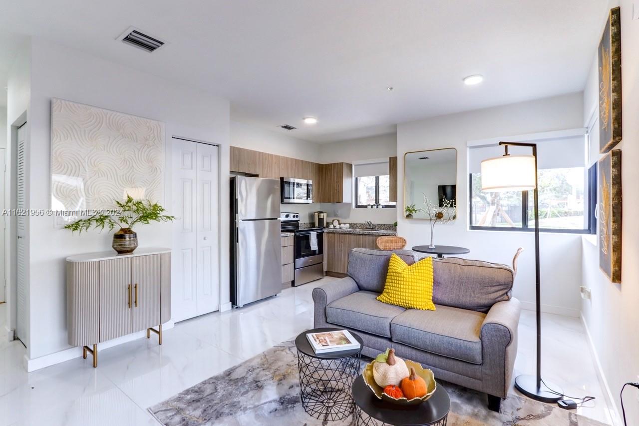 a living room with furniture fireplace and kitchen view