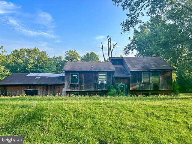 a view of a brick house with a big yard and large trees