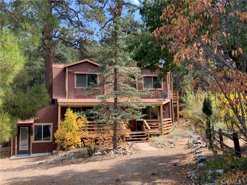 front view of house with a tree in the background