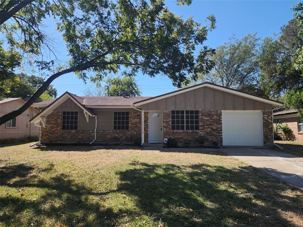 a front view of house with yard and trees in the background