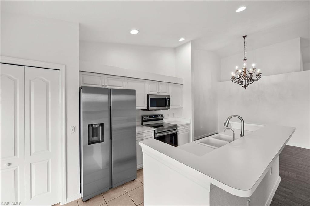 a kitchen with stainless steel appliances kitchen island a refrigerator and a sink