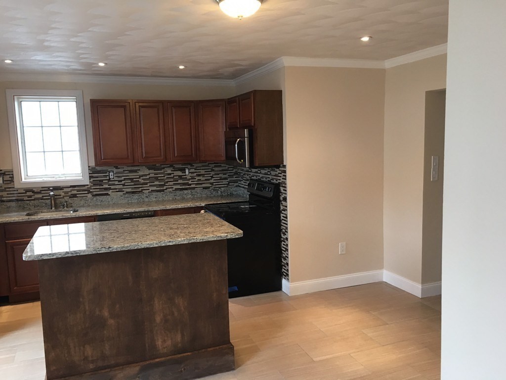 a kitchen with granite countertop stainless steel appliances a sink and a stove