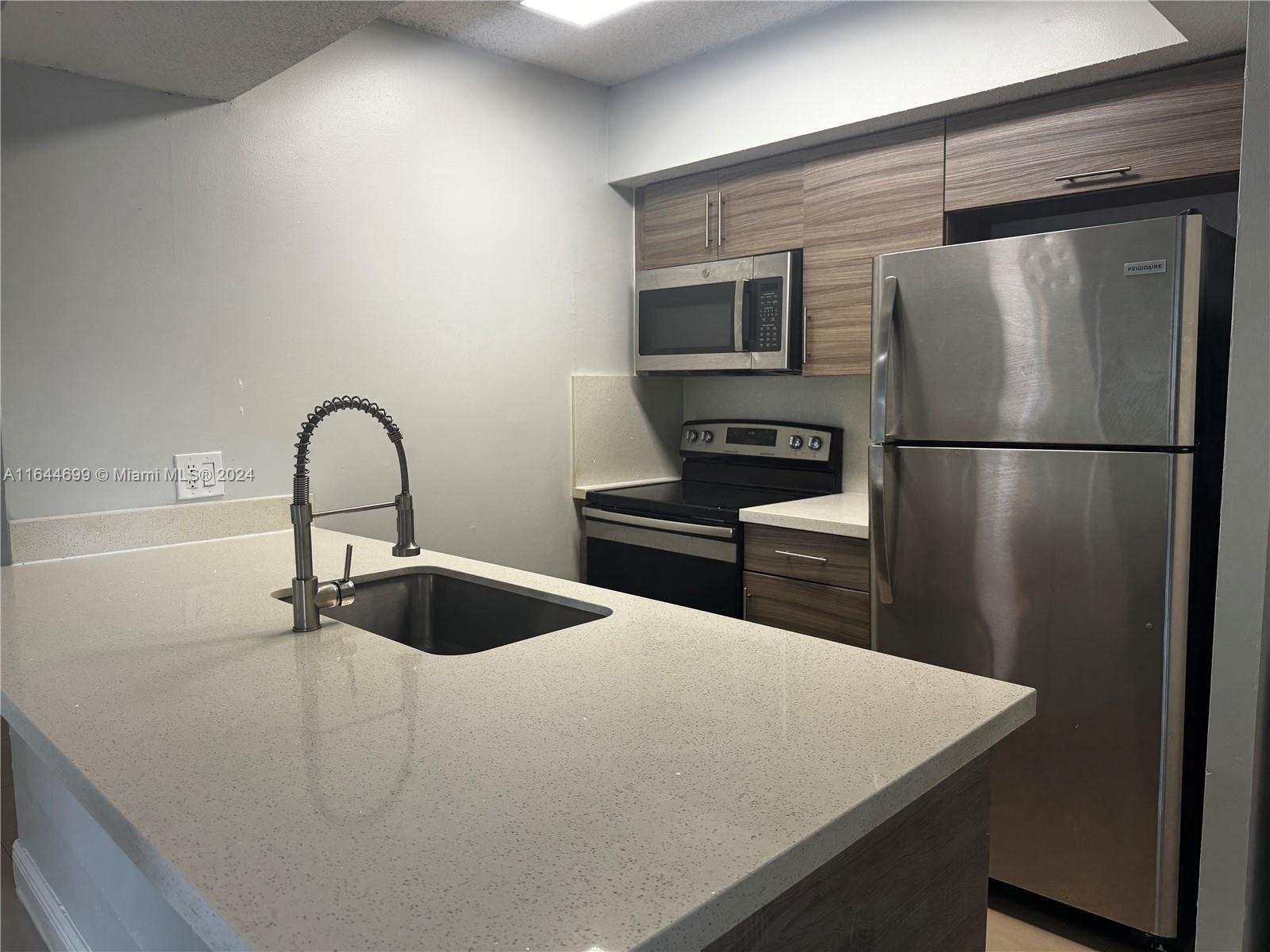 a kitchen with a refrigerator and a sink