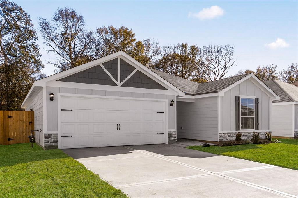 a view of a white house with a yard and garage