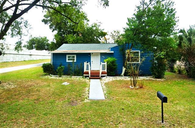 a view of a house with swimming pool and a yard