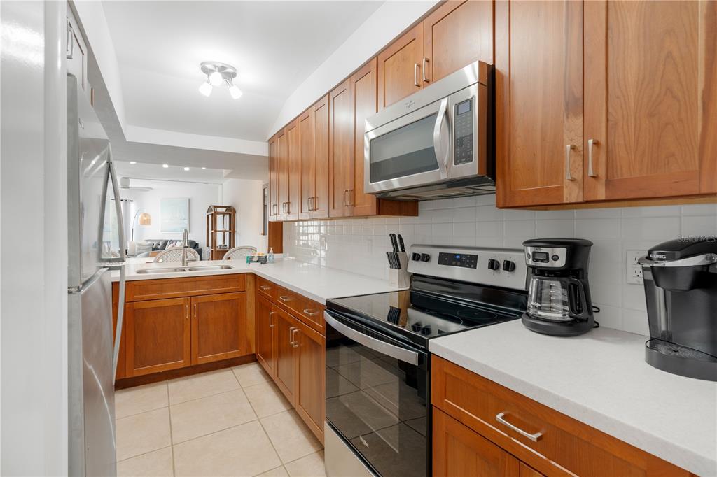 a kitchen with stainless steel appliances granite countertop a stove a sink and a microwave