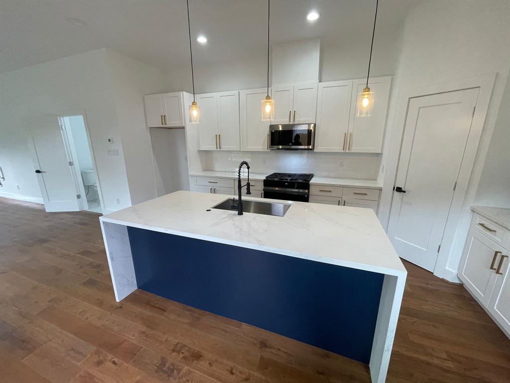 a kitchen with kitchen island a sink appliances and cabinets