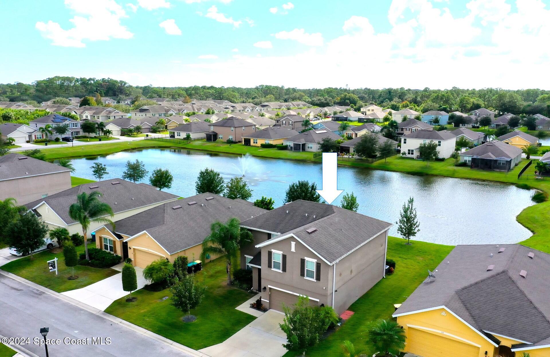 an aerial view of a house with outdoor space and lake view