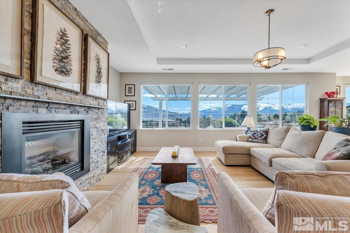 a living room with furniture a fireplace and a large window