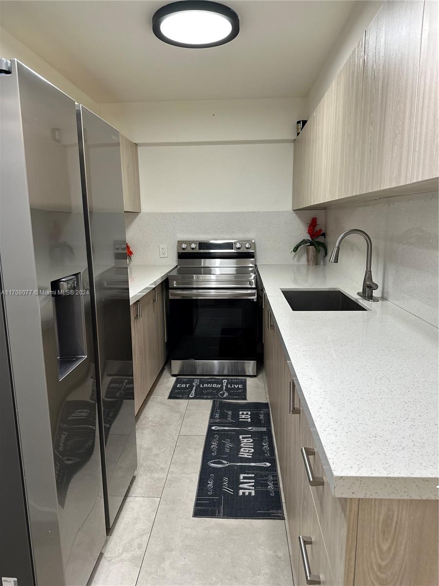 a kitchen with a sink a stove and refrigerator